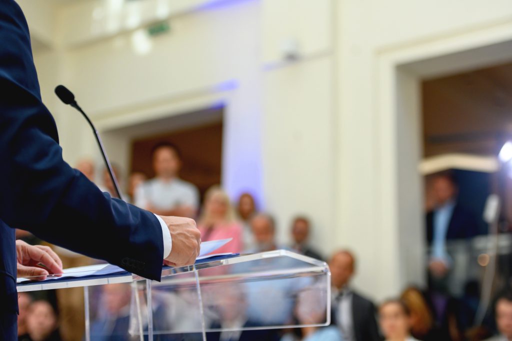 Unrecognizable politician speaking publicly from the lectern