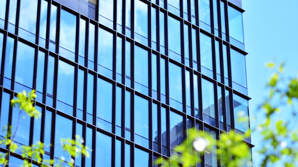 The harmony of nature and modernity. Reflection of modern commercial building on glass with sunlight.