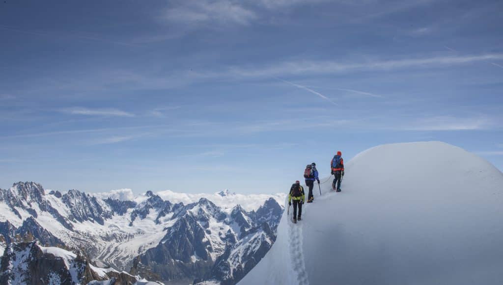 Mountain climbers walk on snow