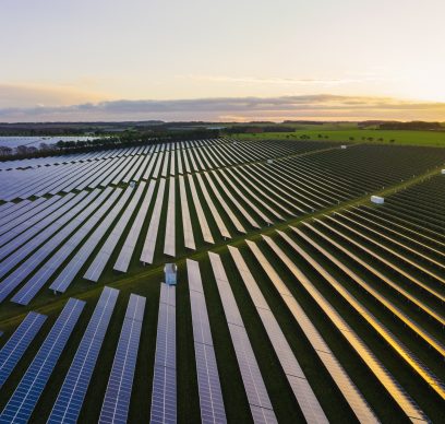 Abstract aerialdrone view over a field of solar panels at sunrise