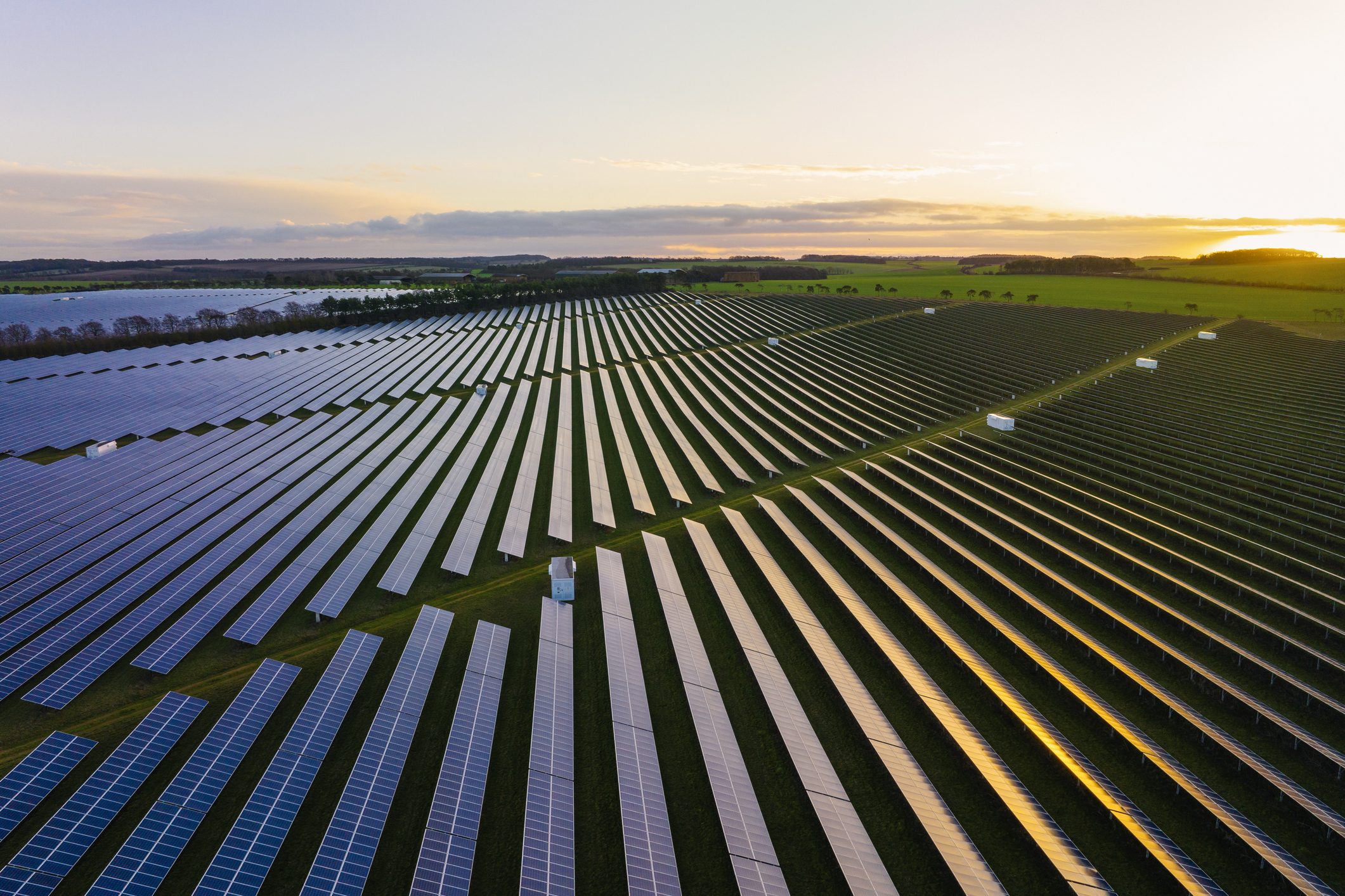 Abstract aerialdrone view over a field of solar panels at sunrise