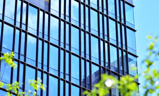 The harmony of nature and modernity. Reflection of modern commercial building on glass with sunlight.