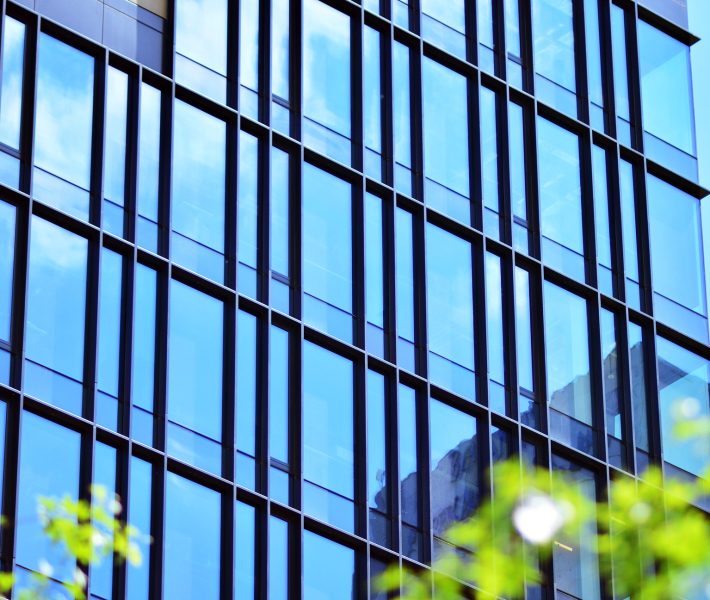 The harmony of nature and modernity. Reflection of modern commercial building on glass with sunlight. Fintechs