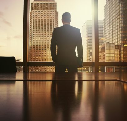 Silhouette of businessman looking out at financial district