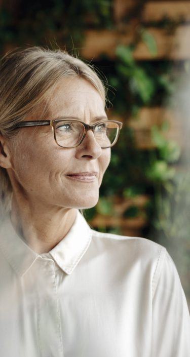 Businesswoman in green office looking out of window