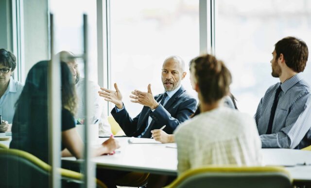 Mature businessman leading project meeting in office conference room