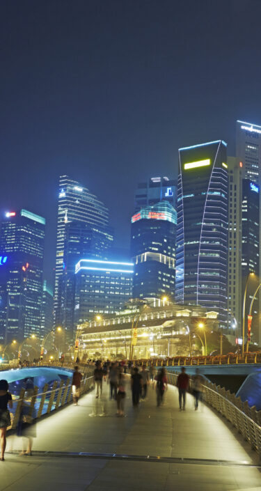 Syline of skyscrapers in the financial district of Singapore and Marina Bay illuminated at night