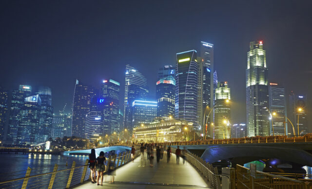 Syline of skyscrapers in the financial district of Singapore and Marina Bay illuminated at night