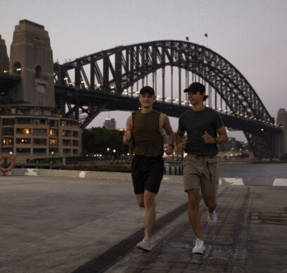 A shot of two young, Caucasian males running along Sydney Harbour, Australia.